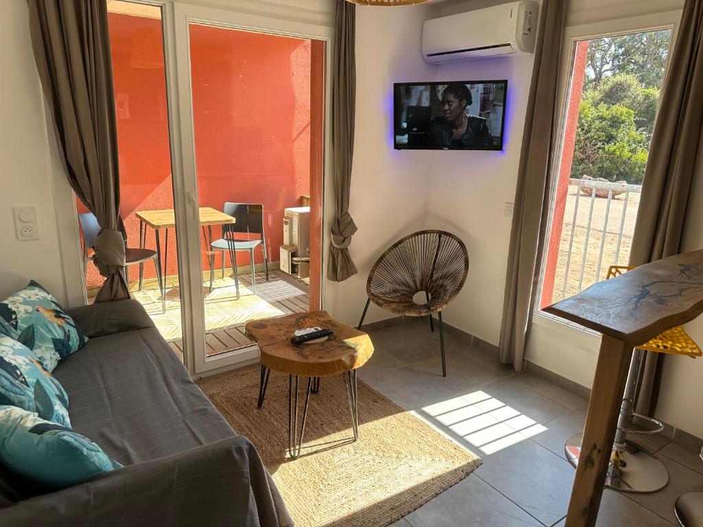 un salon avec un canapé et une table dans l'établissement Résidence les Hameaux de Saint Cyprien appartement LUNA 132, à Lecci