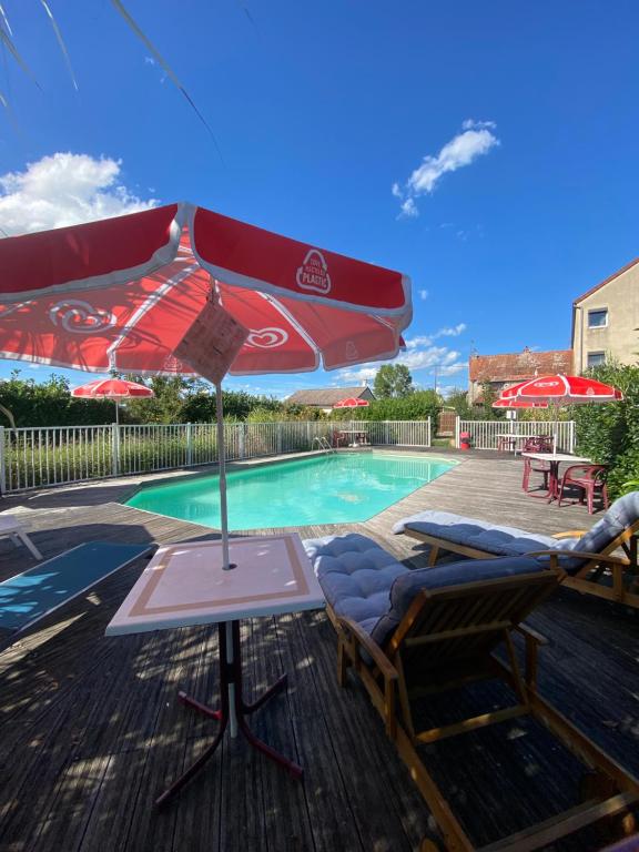 - une piscine avec 2 chaises, une table et un parasol dans l'établissement Hotel Restaurant La Place, à Malay