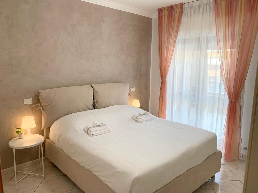 a bedroom with a white bed and a window at La Casetta in Folignano