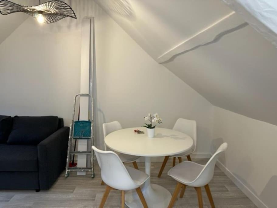 een woonkamer met een tafel en stoelen en een bank bij appartement centre ville LILLEBONNE 2eme etage in Lillebonne