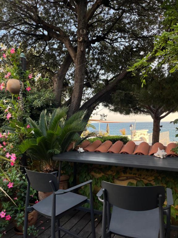 - une terrasse avec 2 chaises, une table et des fleurs dans l'établissement L'Oasis, à Marseille