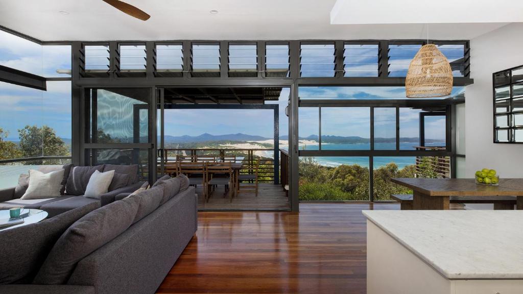 a living room with a couch and a table at One Mile Retreat in Anna Bay