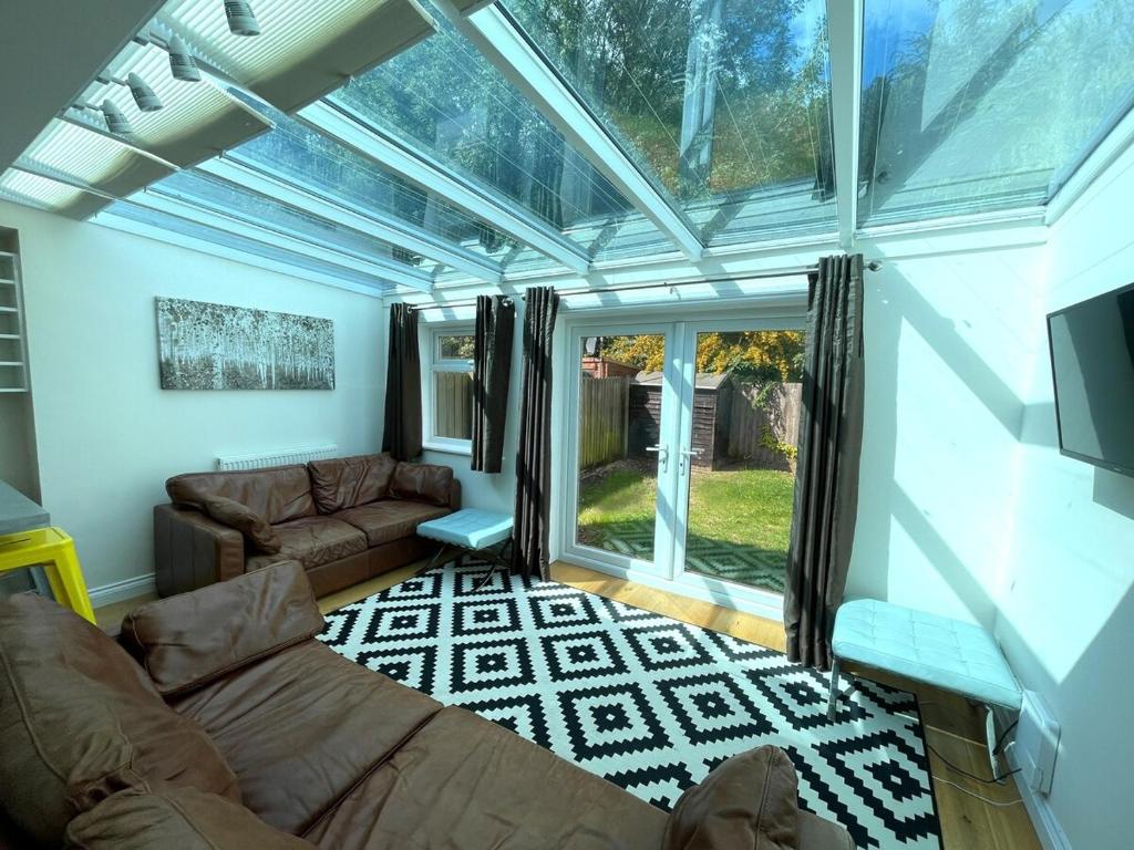 een woonkamer met een groot glazen plafond bij Stunning House In Beautiful Madingley Village 