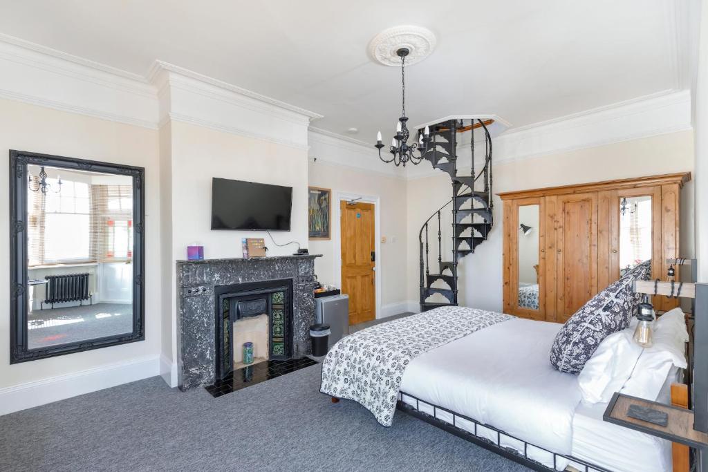 1 dormitorio con 1 cama y chimenea en Finest Retreats - Pittodrie Guest House - Apartment 6 en Brighton & Hove