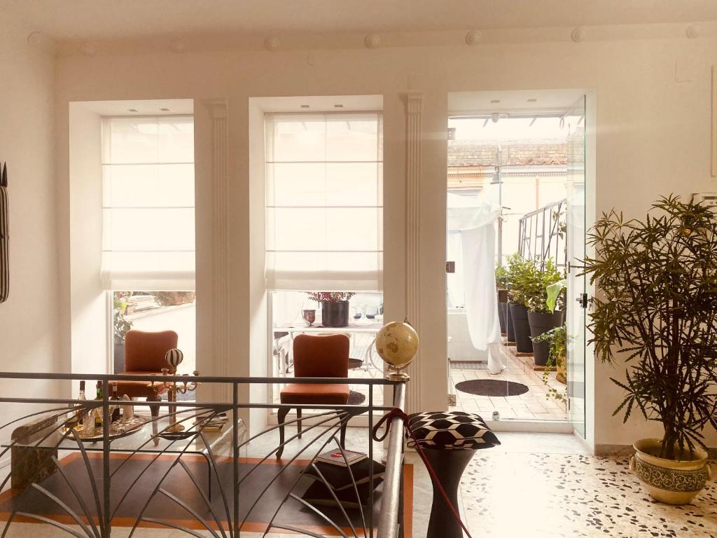 a room with a table and chairs and windows at B&B Liberty in Santa Maria Capua Vetere