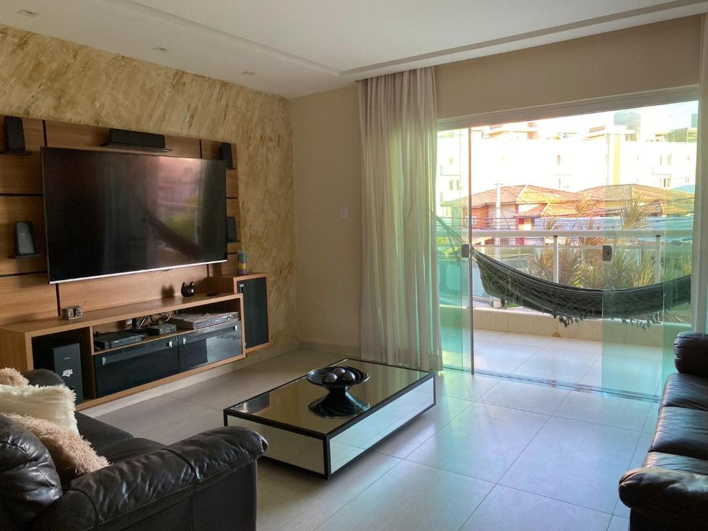 ein Wohnzimmer mit einem Sofa und einem TV in der Unterkunft Casa do Mar Stella Maris in Salvador