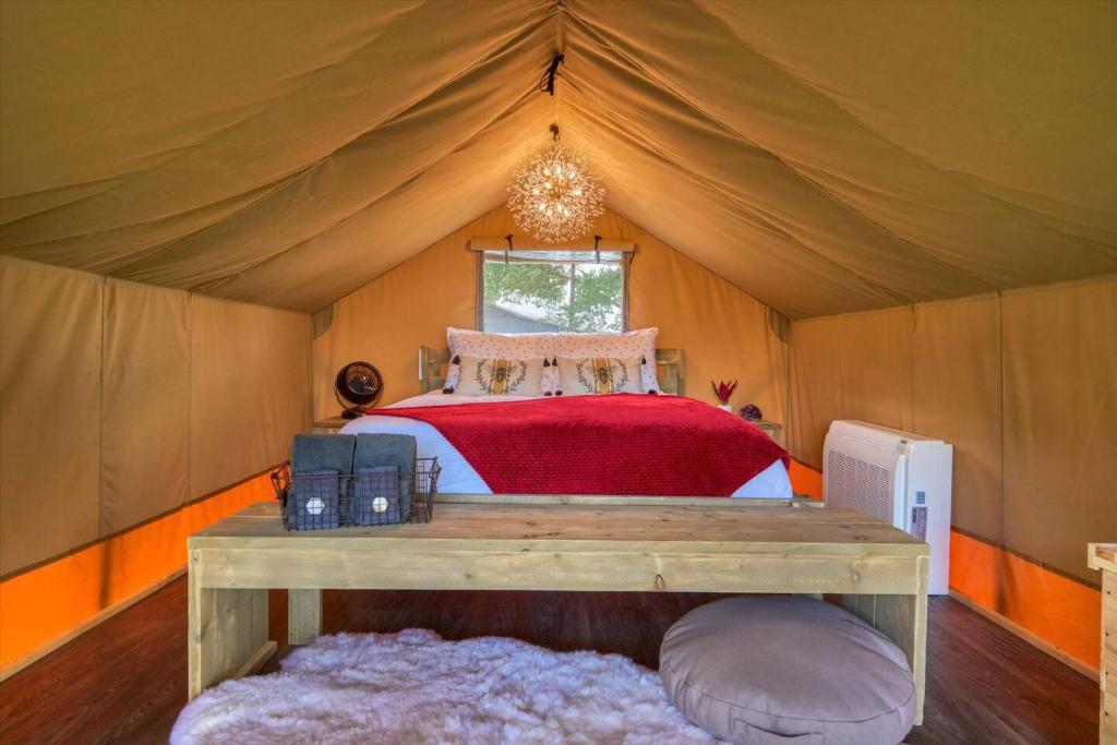 a bedroom with a bed in a tent at Thistle Bee Fun - Safari Tent - BeeWeaver Honey Farm in Navasota