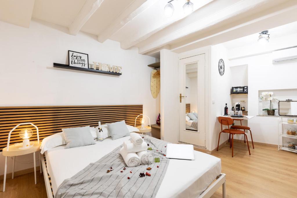 a white bedroom with a bed and a kitchen at Dimora Pastini in Rome