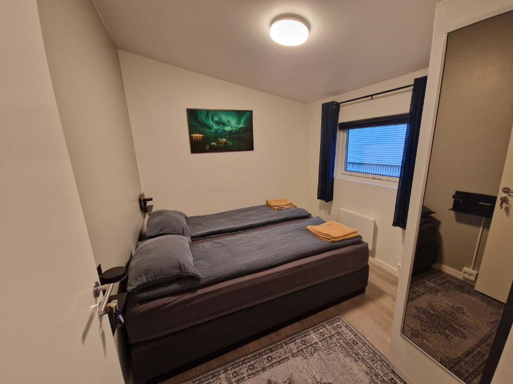 um pequeno quarto com uma cama num quarto em Northern living 2 room with shared bathroom em Tromsø