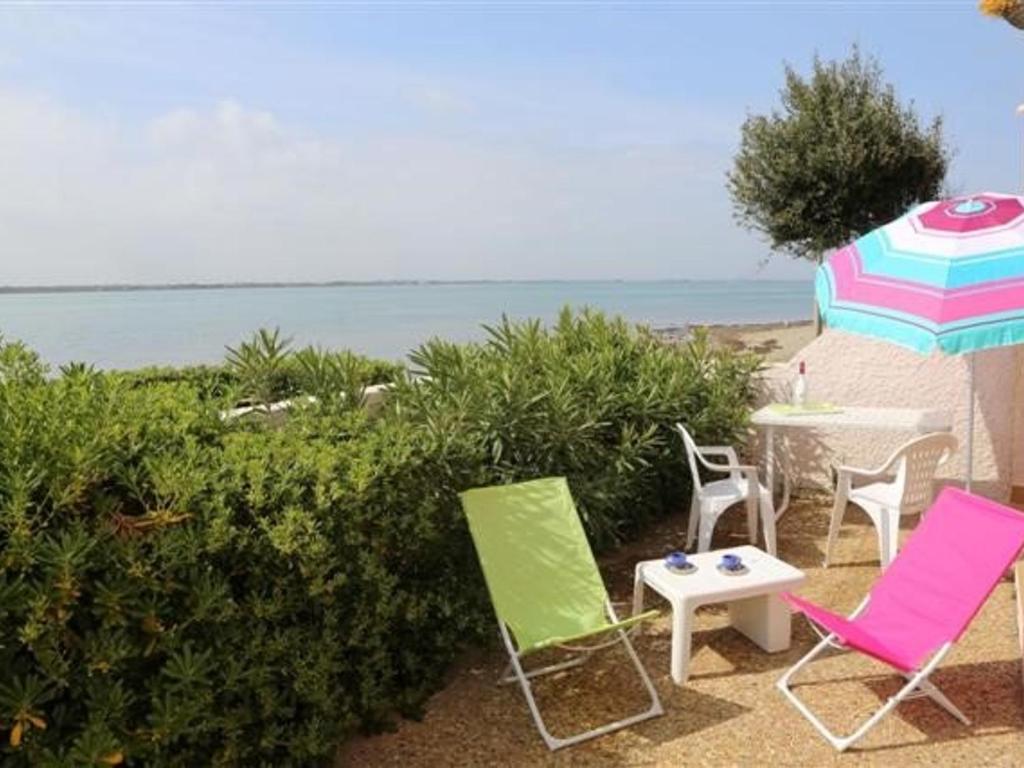 - 2 chaises, une table et un parasol sur la plage dans l'établissement Appart 4 pièces, 8 pers, piscine, tennis, parking inclus - Port Barcarès - FR-1-195-58, au Barcarès