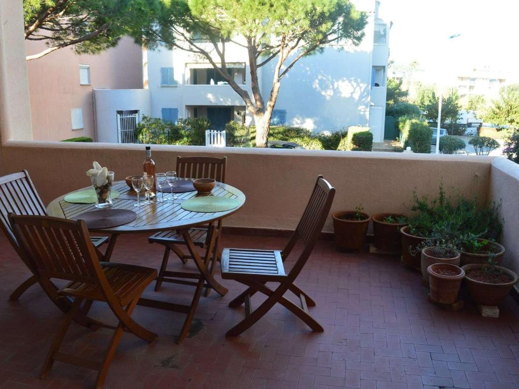 een tafel en stoelen op een patio met planten bij Appartement Cavalaire-sur-Mer, 2 pièces, 4 personnes - FR-1-226B-27 in Cavalaire-sur-Mer