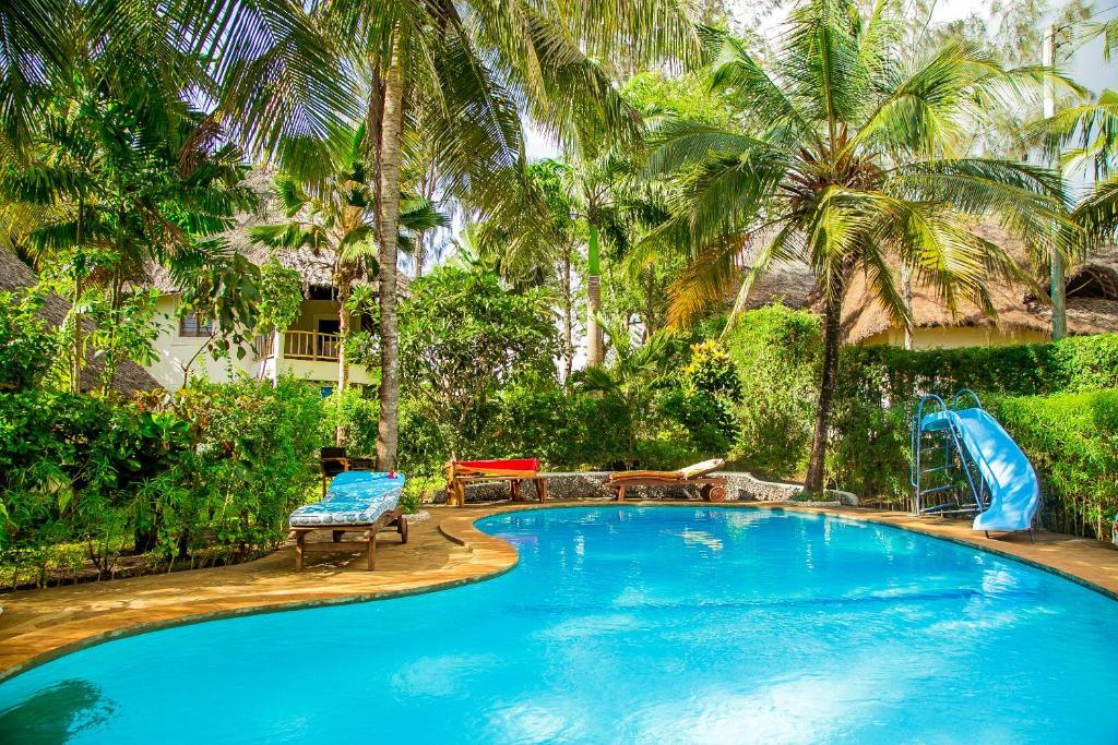 a swimming pool with a slide in a resort at 3 Bed Villa Sleeps 6 - Pool Garden Chef Option in Diani Beach