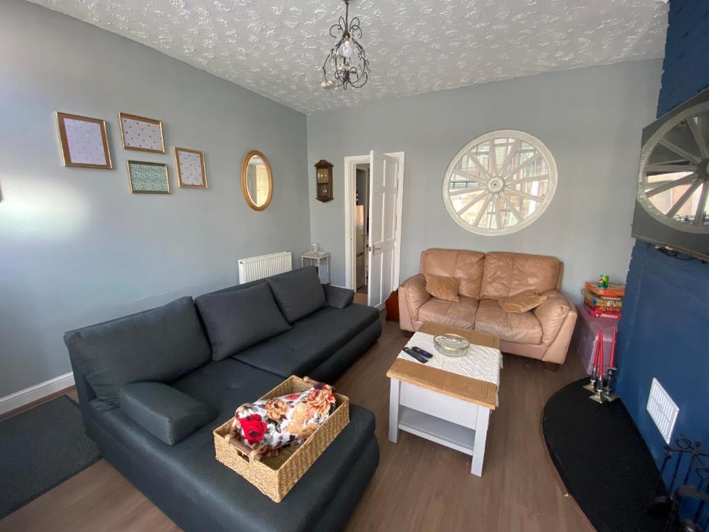 een woonkamer met een bank en een tafel bij Cosy and Comfortable Newly Refurbished Family Home in Hull