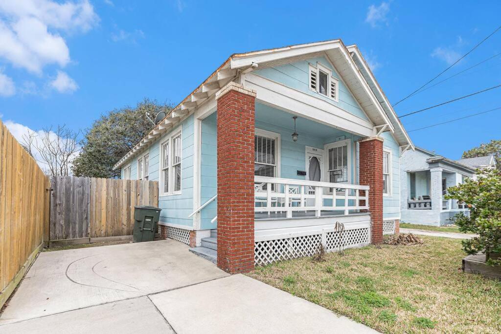 una casa bianca con portico e recinzione di Festive Nest - Tranquil Escape Close to the Beach a Galveston