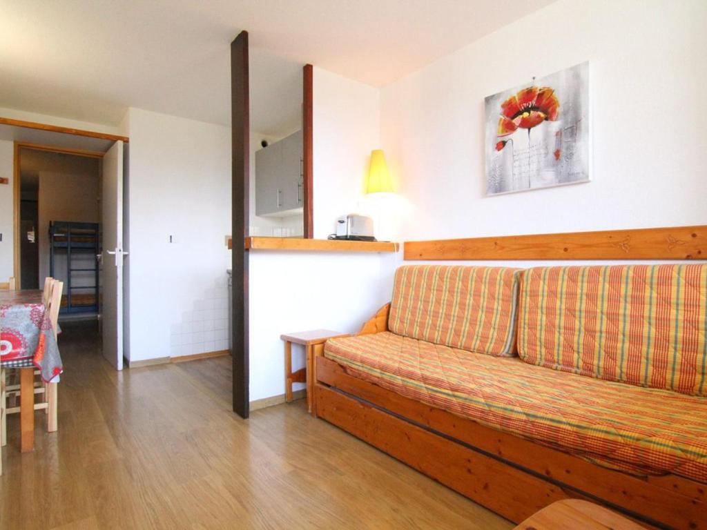 un salon avec un canapé et une table dans l'établissement Appartement cosy 6 pers. avec balcon, proche pistes et commerces - Alpe d'Huez - FR-1-405-99, à L'Alpe-d'Huez