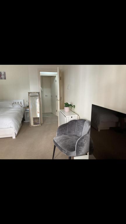 a bedroom with a bed and a chair and a mirror at Cosy central London flat Trafalgar Square in London