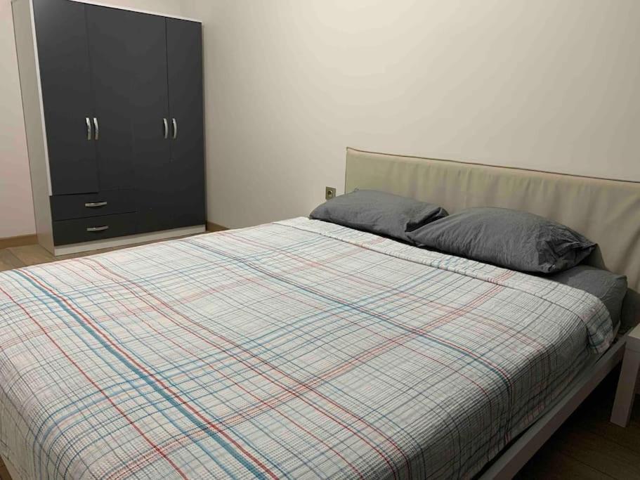 ein Bett mit einer karierten Decke und einem schwarzen Schrank in der Unterkunft Beautiful apartment 2+1 in Istanbul