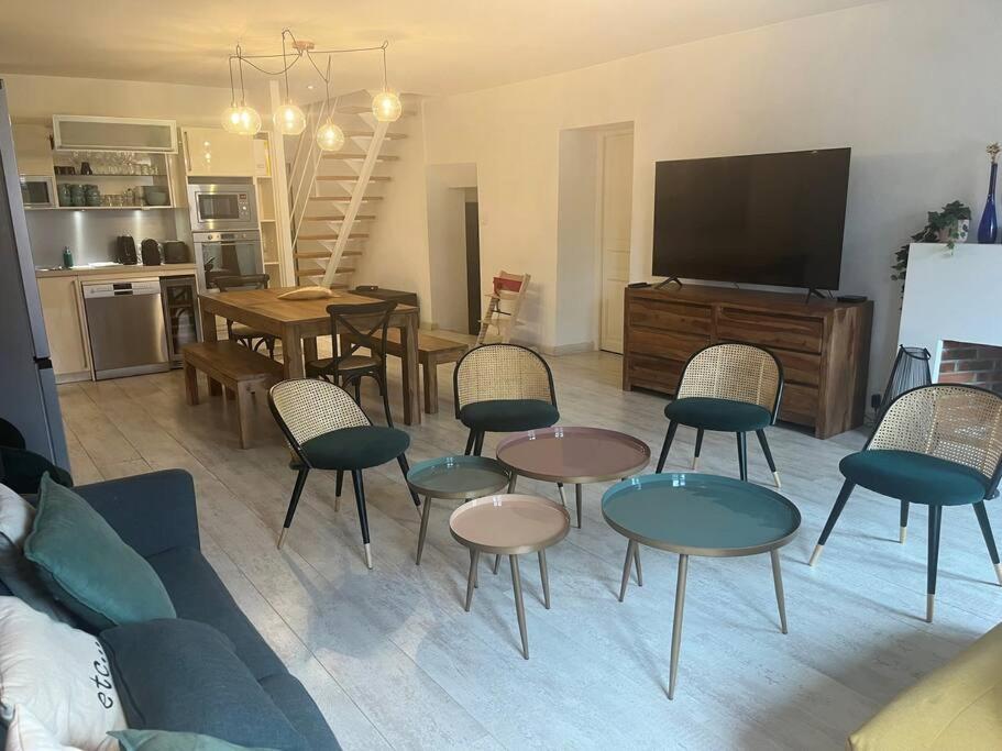 a living room with chairs and tables and a tv at L'escalier du Château T4 Duplex 9 couchages 4* in Annecy
