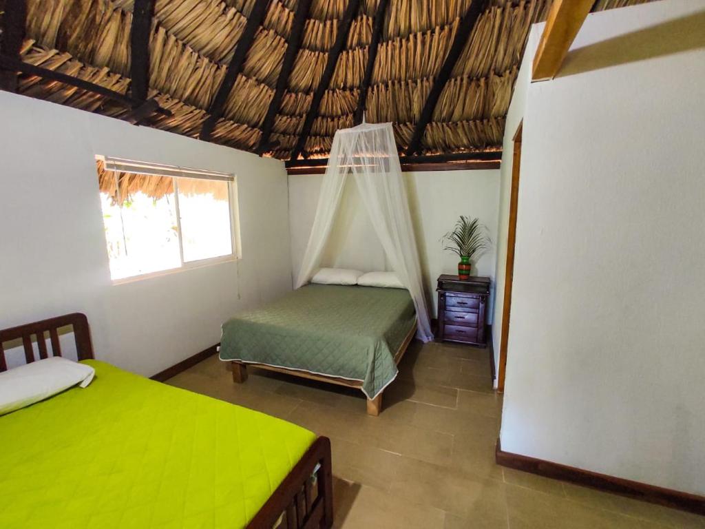 a bedroom with two beds and a hammock in it at Makuruma Chalet in Palomino