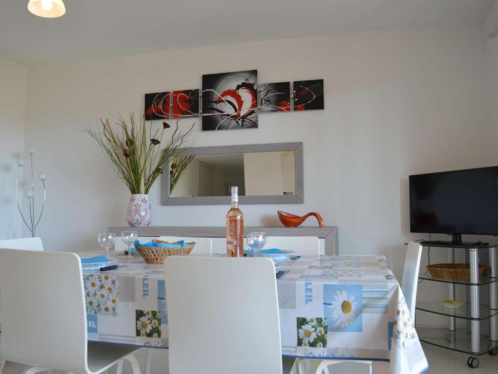 a dining room table with white chairs and a mirror at Appartement Saint-Raphaël, 3 pièces, 4 personnes - FR-1-226A-274 in Saint-Raphaël