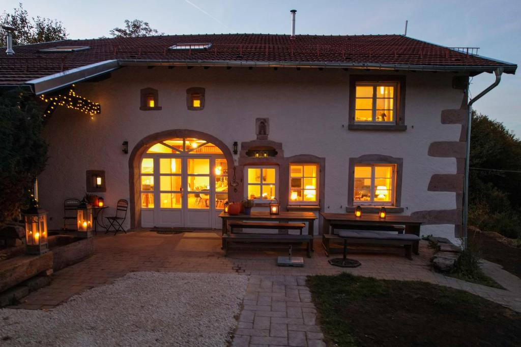 ein Haus mit beleuchteten Fenstern und einer Terrasse in der Unterkunft La Belle Des Vosges in Le Tholy