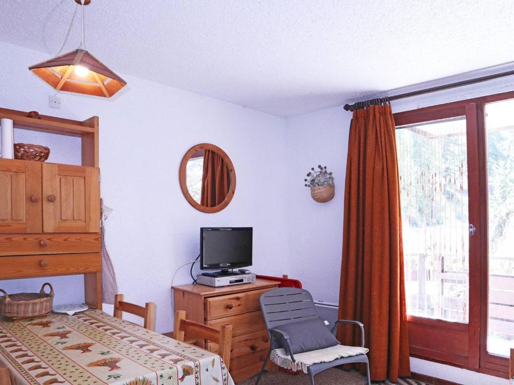 une chambre avec un lit et une télévision sur une commode dans l'établissement Skis aux pieds! Superbe studio 6 pers., proche station, balcon Sud Ouest, tout équipé - FR-1-322-290, aux Orres
