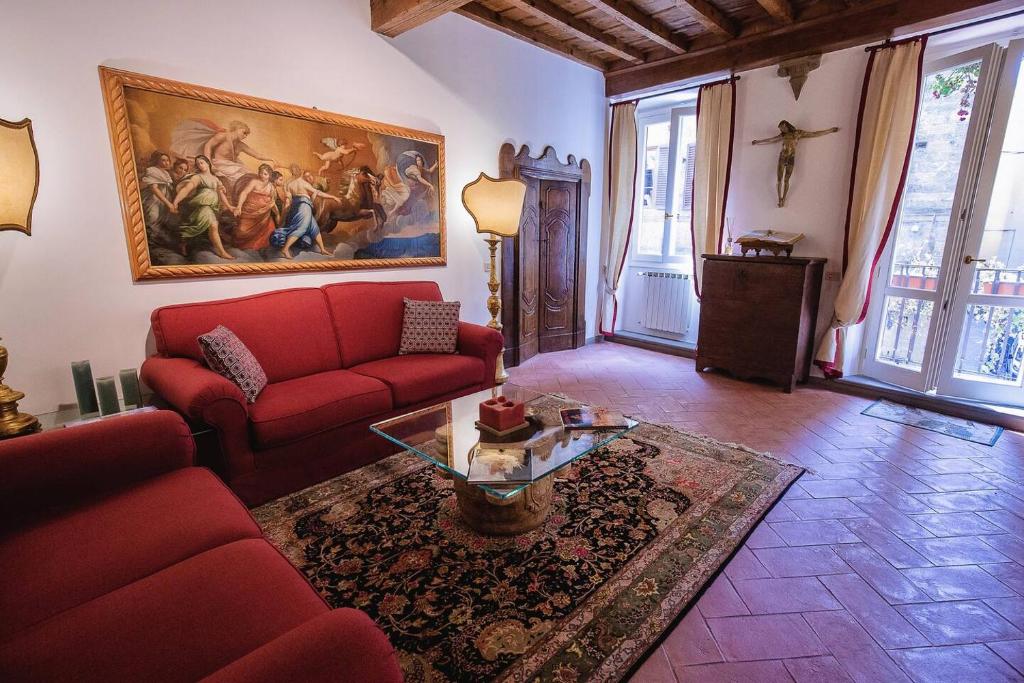 a living room with a red couch and a table at Acacia Firenze - Adelfa in Florence