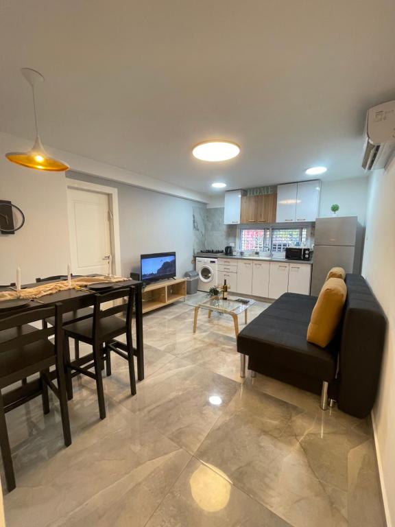 ein Wohnzimmer mit einem Esstisch und einer Küche in der Unterkunft הטרקלין של לינוי - 5 דקות נסיעה מהים in Aschkelon