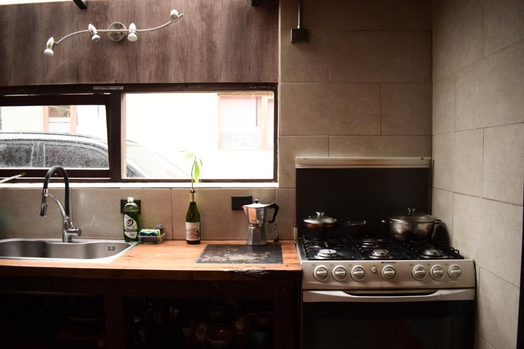 uma cozinha com um fogão e um lavatório em Habitación privada en casa compartida em San Carlos de Bariloche