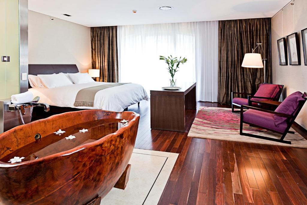 a bedroom with a bed and a tub in a room at Mio Buenos Aires in Buenos Aires