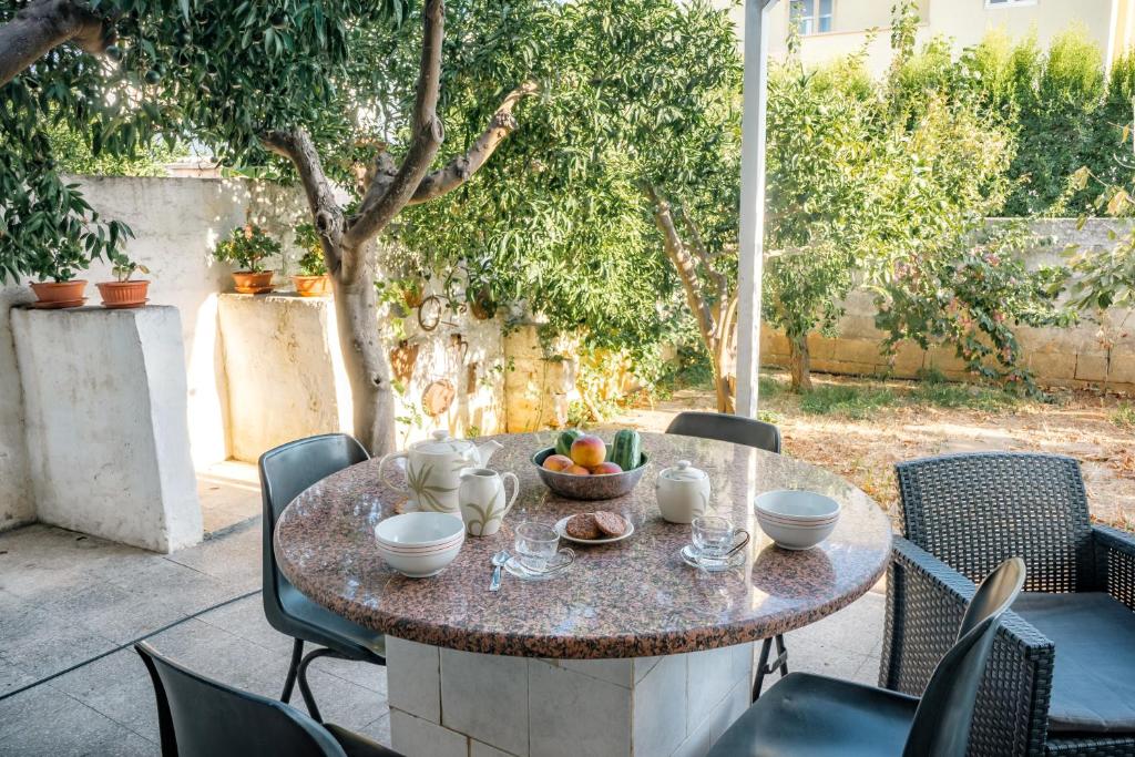 una mesa con un bol de fruta en el patio en A 10 MINUTI DA GALLIPOLI BELLISSIMO APPARTAMENTO CON GIARDINO, en Taviano