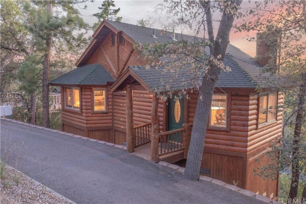 a log cabin with a porch in the woods at Bearadise Retreat in Big Bear Lake