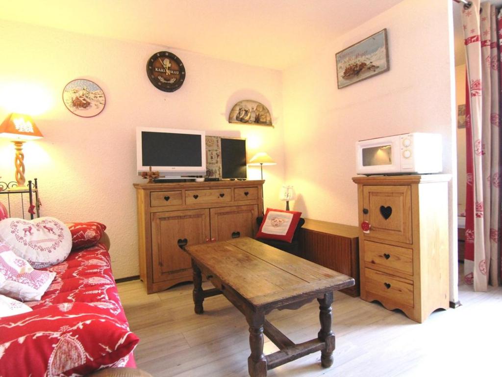 a living room with a couch and a television on a dresser at Appartement Huez, 2 pièces, 5 personnes - FR-1-405-26 in L'Alpe-d'Huez