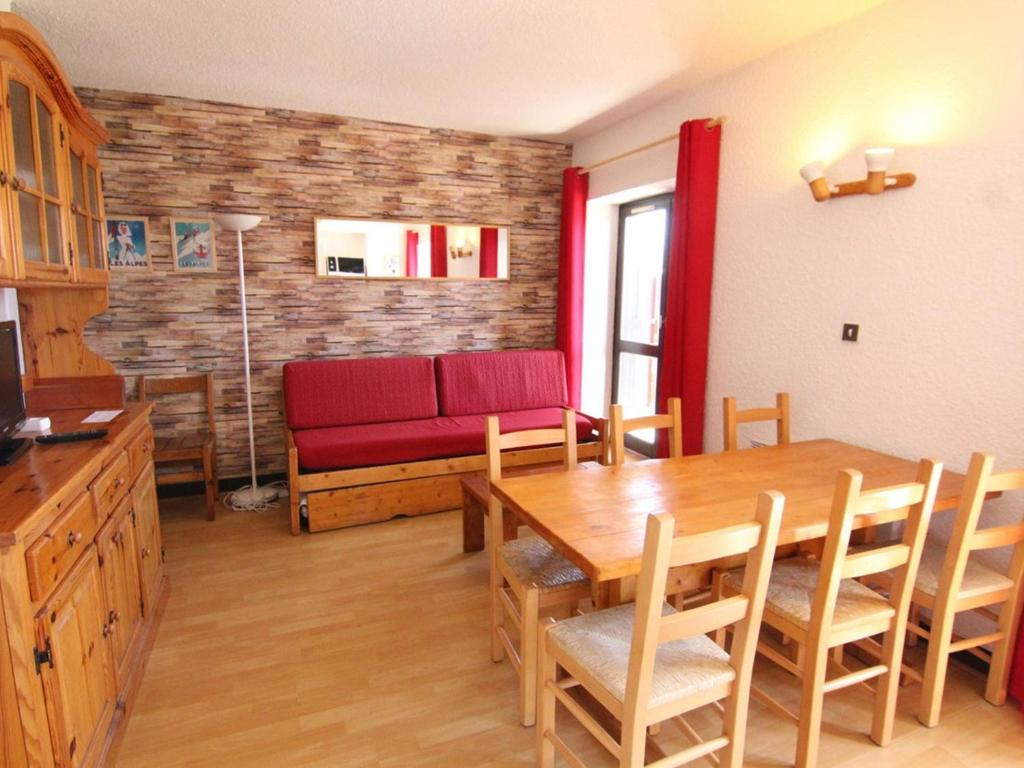 uma sala de estar com uma mesa e um sofá vermelho em Appartement Huez, 2 pièces, 6 personnes - FR-1-405-27 em Alpe-d'Huez
