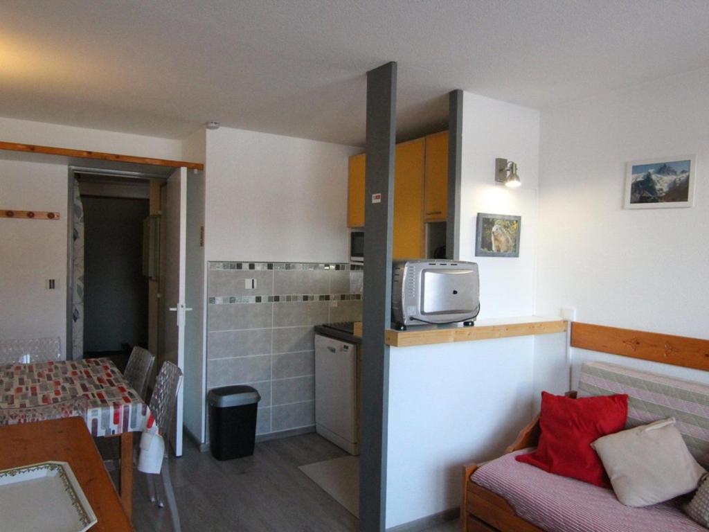 Cette chambre comprend une cuisine et une table avec un lit. dans l'établissement Studio cosy pour 5 pers. à 100m des pistes - Balcon sud, animaux acceptés, près commerces - Alpe d'Huez - FR-1-405-64, à L'Alpe-d'Huez