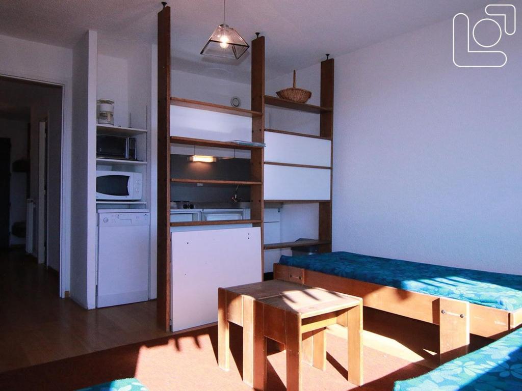 Cette petite chambre comprend une cuisine, une table et un canapé. dans l'établissement Studio cosy pour 4 pers. à 90m des pistes – Balcon sud, commerces et école de ski à proximité - FR-1-405-65, à L'Alpe-d'Huez
