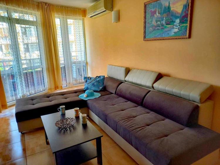 a living room with a couch and a table at Central Plaza Apartment in Sunny Beach