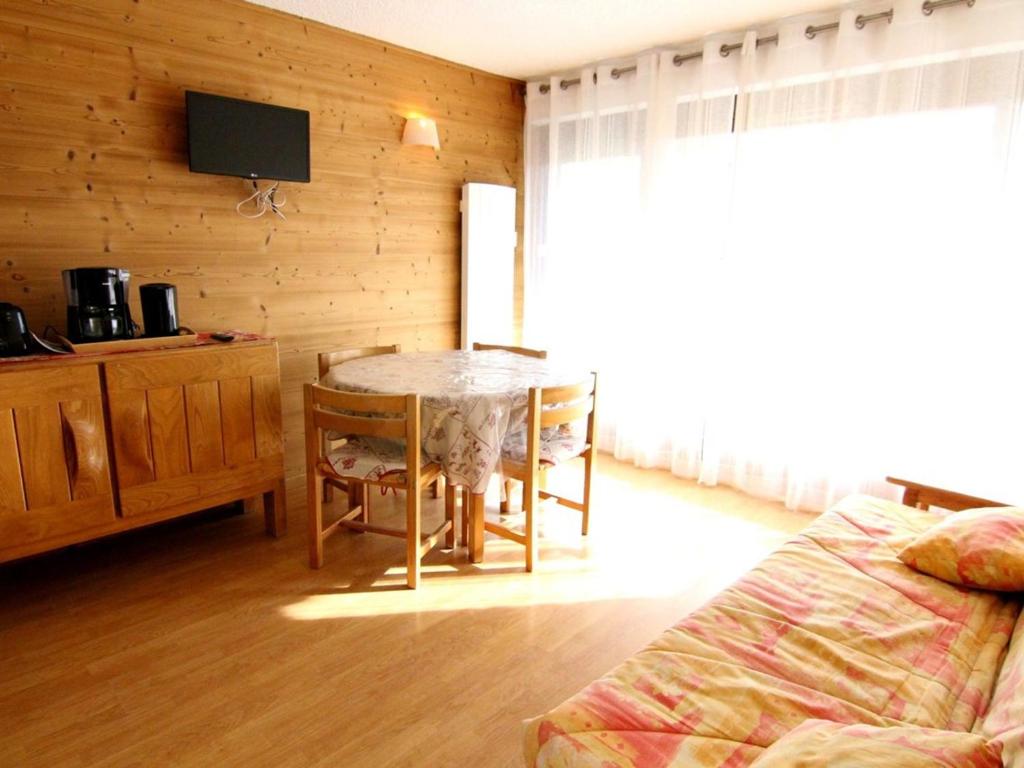 Cette chambre comprend une table, un lit et une télévision. dans l'établissement Appartement cosy au cœur de l'Alpe d'Huez - 6 pers, 38m², balcon sud, skis à 240m - FR-1-405-79, à L'Alpe-d'Huez