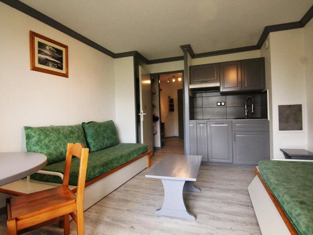 a living room with a couch and a table at Studio cosy avec balcon, piscine & sauna - 3 pers, pied des pistes, animaux OK - FR-1-405-87 in L'Alpe-d'Huez