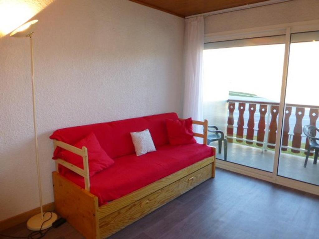 ラルプ・デュエズにあるAppartement Huez, 1 pièce, 4 personnes - FR-1-405-101の大きな窓付きの客室で、赤いソファが備わります。