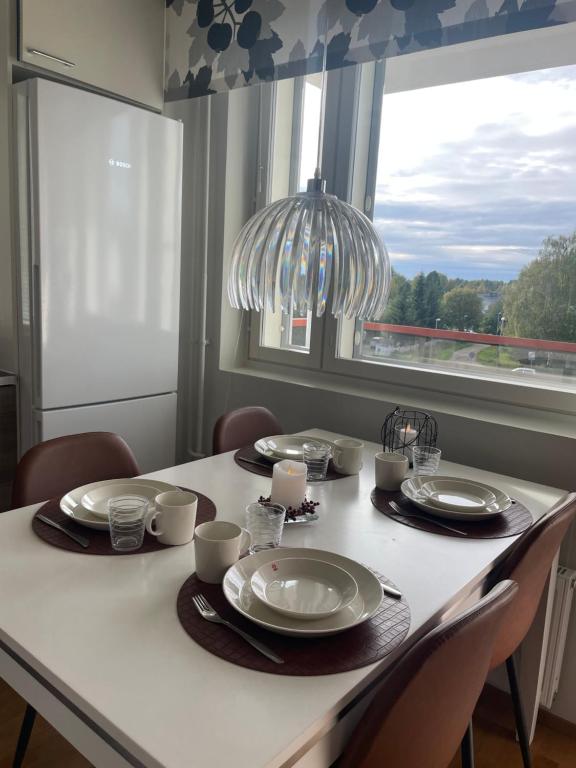 een eettafel met stoelen en een kroonluchter bij Adorable Arctic Apartment with sauna in Rovaniemi