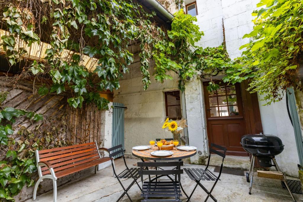 d'une terrasse avec une table, des chaises et un banc. dans l'établissement Le Petit Yogi, 5 minutes du ZooParc de Beauval, à Saint-Aignan