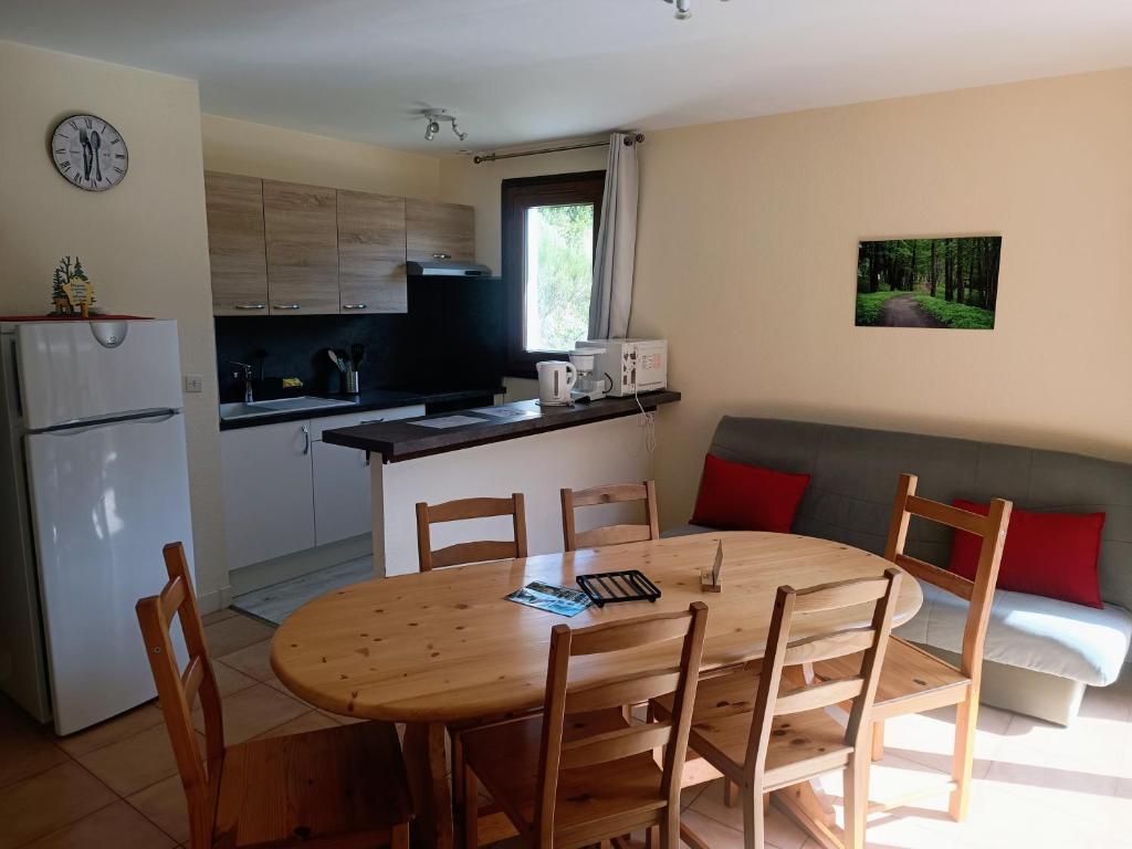 a kitchen and dining room with a wooden table and chairs at Les Ecureuils "Les Faons" in Roubion