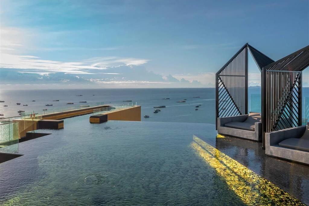 a swimming pool with the ocean in the background at Downtown Chic Condo High Floor #ES54624 in Pattaya Central