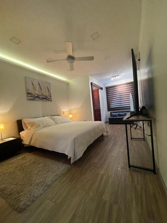 1 dormitorio con 1 cama y TV de pantalla plana en Kiran Lodging Guayaquil, en Guayaquil