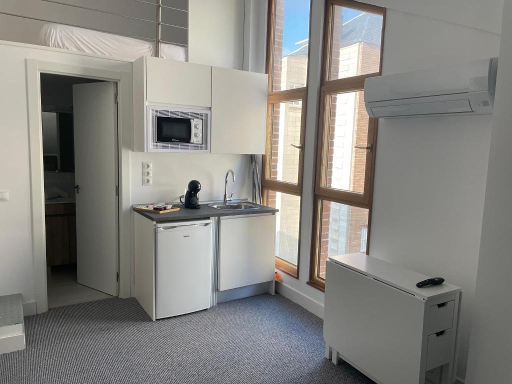 a kitchen with white cabinets and a sink and a window at C9 Magnífico apartamento en zona tranquila in Madrid