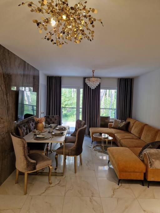 ein Wohnzimmer mit einem Sofa und einem Tisch in der Unterkunft Pobierowo Baltic Apartments Złoty C17 Basen in Pobierowo