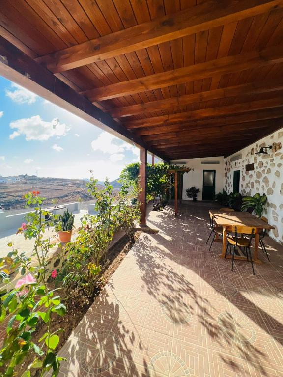 a patio with a wooden roof with a table and chairs at Casa Abuela Inés in Puerto del Rosario