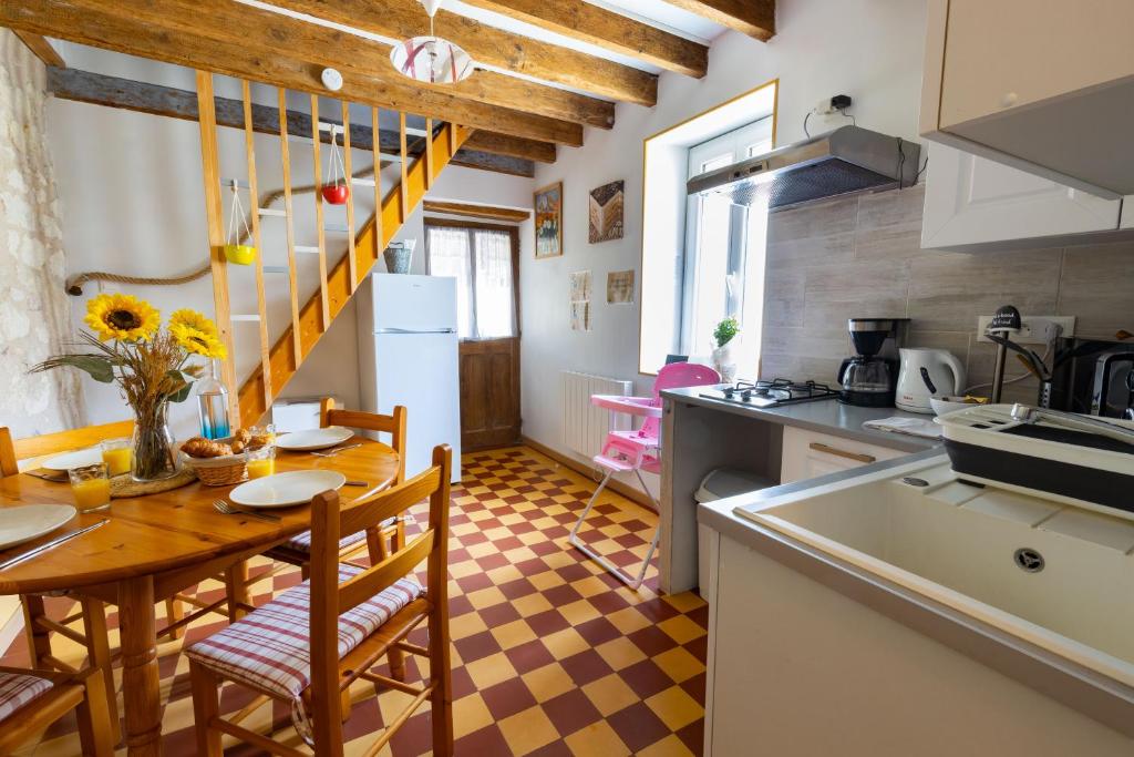uma cozinha e sala de jantar com mesa e cadeiras em La maisonnette du Vivier em Couffy