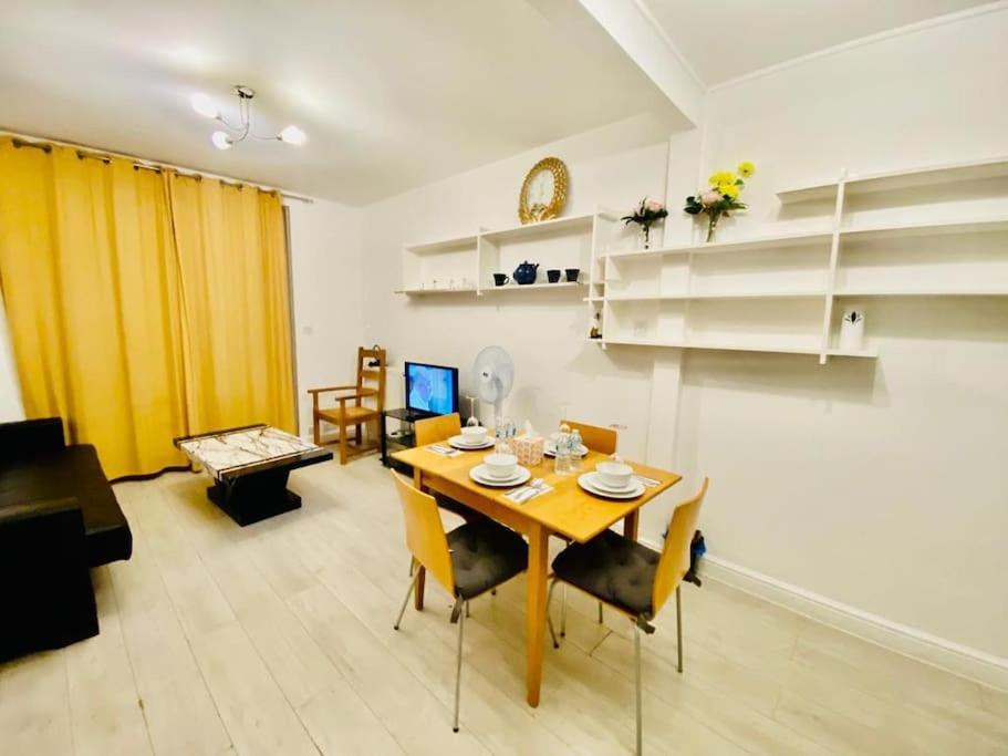 ein Wohnzimmer mit einem Holztisch und Stühlen in der Unterkunft Two Bedroom house on Ground Floor in London in London
